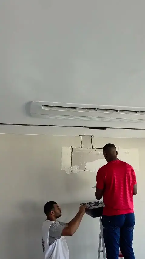 Dupla de técnicos da LR Refrigeração instalando uma unidade interna